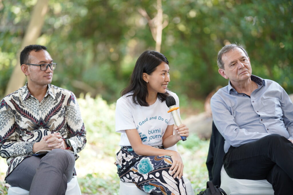 Jessica Novia memakai baju Bumi Journey duduk di tengah peserta konferensi climate session memaparkan tentang sustainability perusahaan