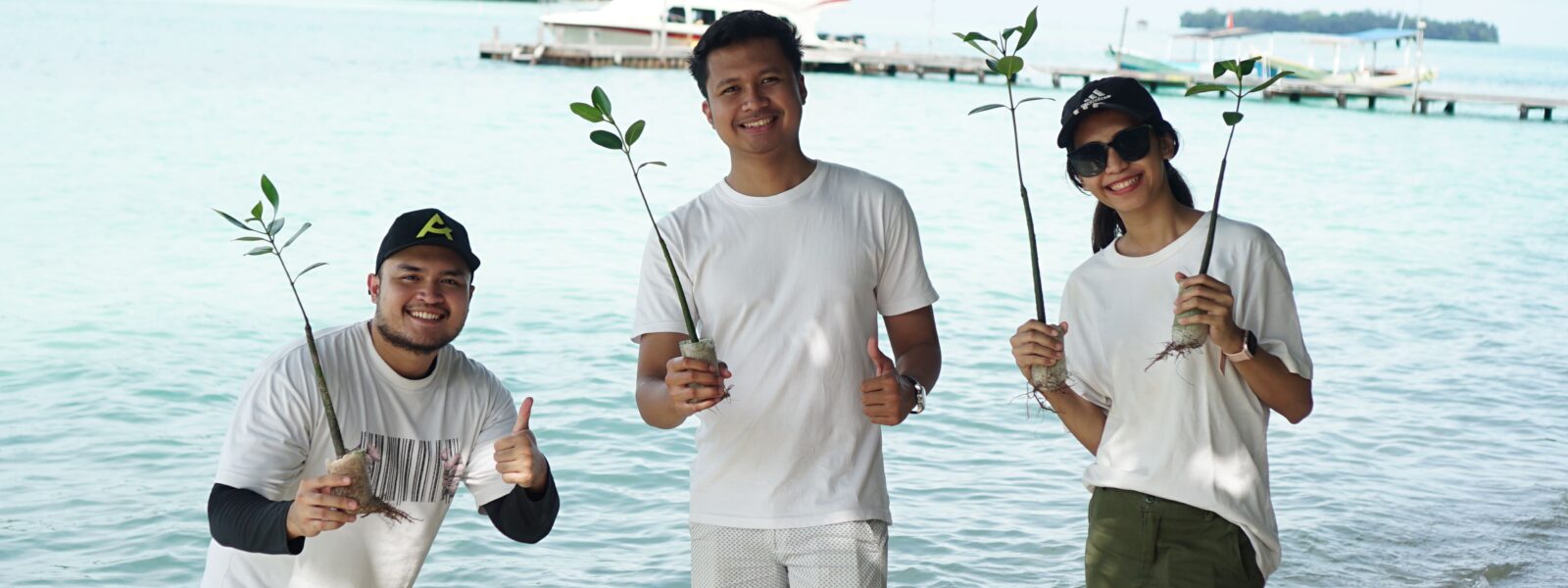 Buat Outing Kantor Anda Jadi Momen Untuk Recharge, Bukan Sekadar Senang-senangmemakai seragam putih Bumi Journey dan memegang bibit mangrove di tepi pantai