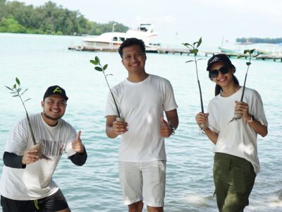 Buat Outing Kantor Anda Jadi Momen Untuk Recharge, Bukan Sekadar Senang-senangmemakai seragam putih Bumi Journey dan memegang bibit mangrove di tepi pantai